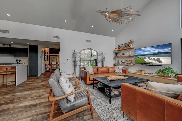 living room featuring high vaulted ceiling, wood finished floors, and visible vents
