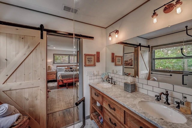 bathroom with a sink, ensuite bath, double vanity, and visible vents