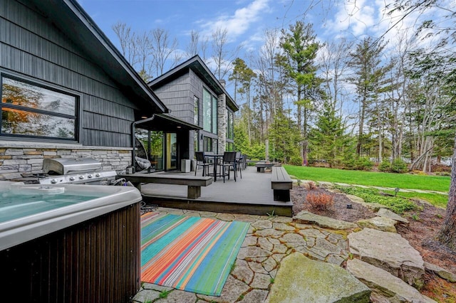 view of patio / terrace with a hot tub, a deck, and area for grilling