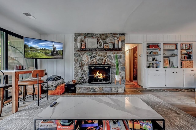 living area with visible vents and a stone fireplace