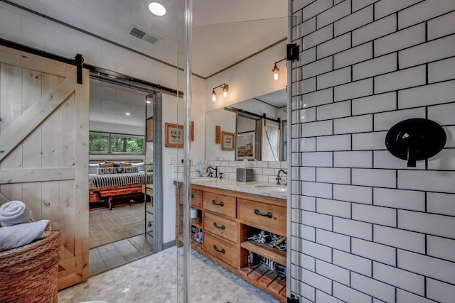 ensuite bathroom featuring a sink, ensuite bath, double vanity, and visible vents