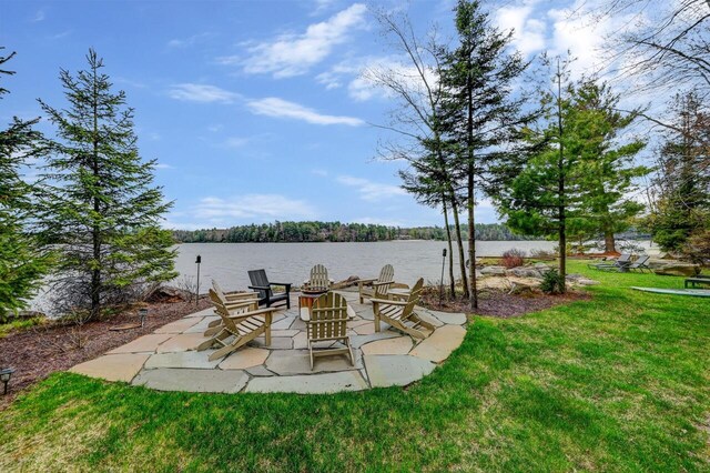 view of yard with a water view, a patio area, and an outdoor fire pit