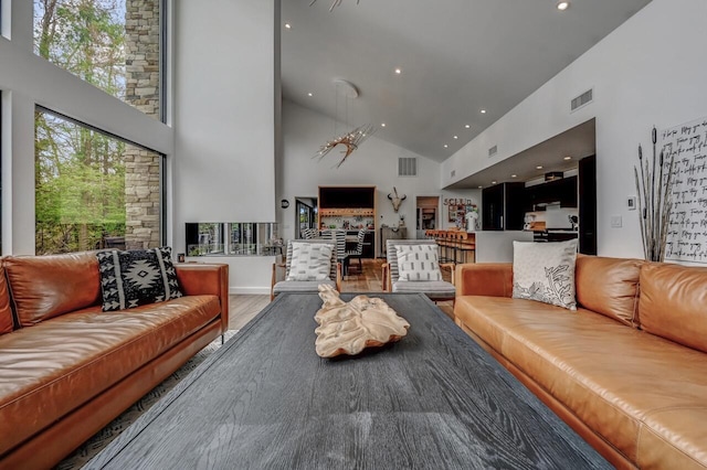 living room with recessed lighting, high vaulted ceiling, visible vents, and wood finished floors