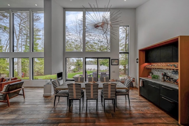 dining space featuring a high ceiling, dark wood-style floors, and a wealth of natural light