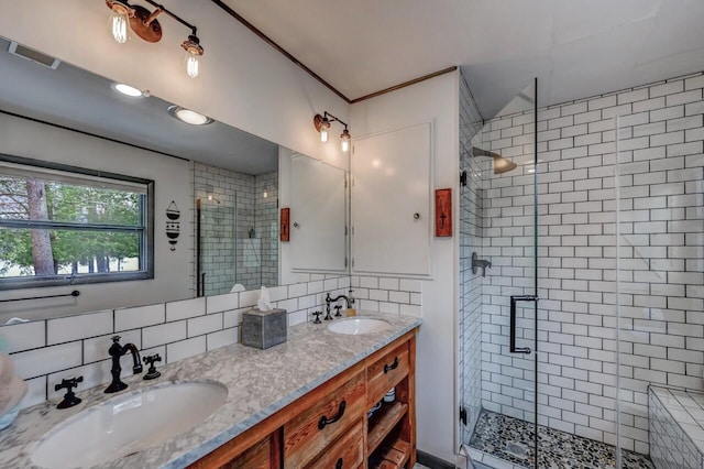 bathroom with visible vents, a sink, decorative backsplash, and a shower stall