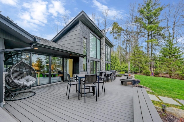 wooden deck with a yard and outdoor dining space