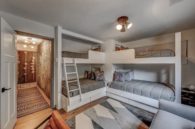 bedroom featuring visible vents, wood finished floors, and a chandelier