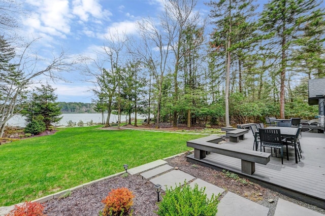 view of yard featuring a deck with water view and outdoor dining area