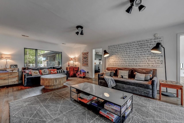 living room featuring visible vents, ceiling fan, and wood finished floors