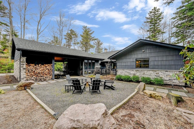 rear view of house with a patio area and stone siding