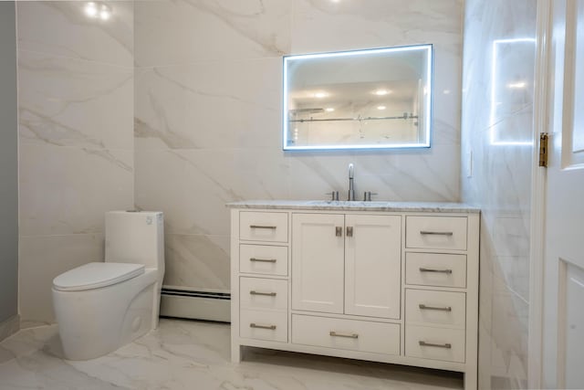 bathroom featuring vanity, toilet, marble finish floor, tile walls, and a baseboard heating unit