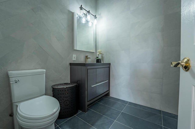 bathroom featuring vanity, tile patterned floors, toilet, and tile walls