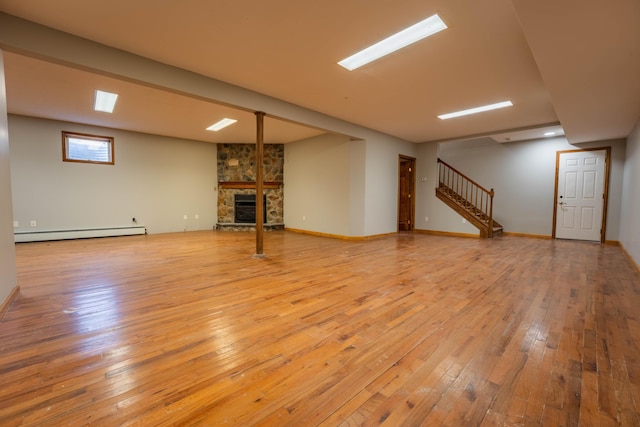 below grade area featuring a fireplace, stairs, hardwood / wood-style flooring, and a baseboard radiator