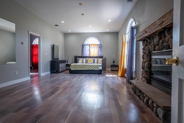 living area with a stone fireplace, recessed lighting, baseboards, wood finished floors, and visible vents