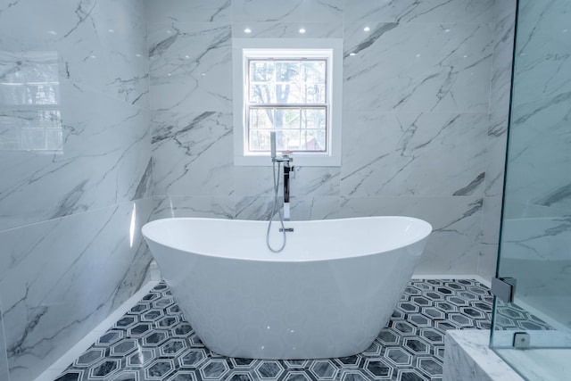 bathroom featuring a freestanding bath and tile walls