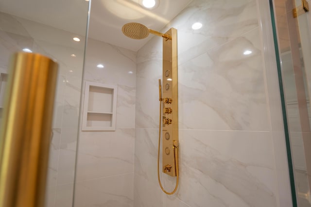 bathroom featuring a marble finish shower