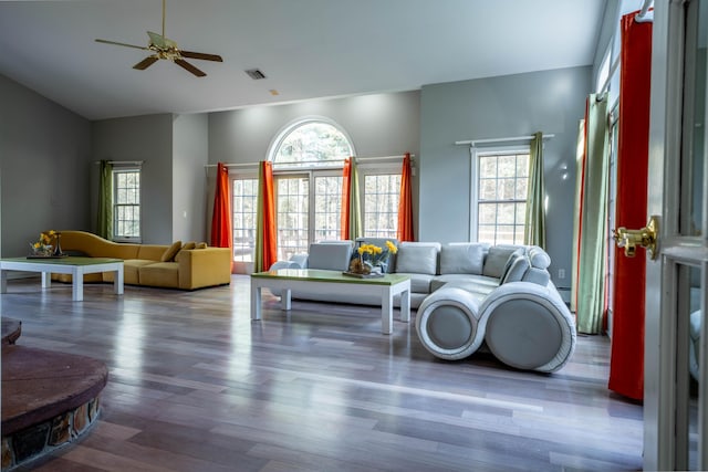living area with ceiling fan, wood finished floors, lofted ceiling, a baseboard radiator, and visible vents