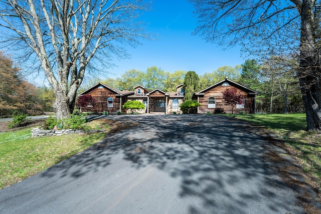 ranch-style home with a front yard and aphalt driveway