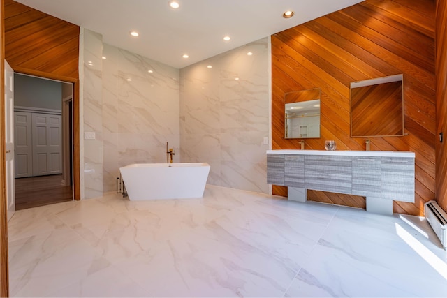 bathroom with double vanity, recessed lighting, and a soaking tub
