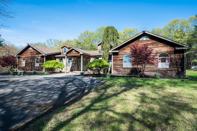 view of front of property with stone siding and a front lawn