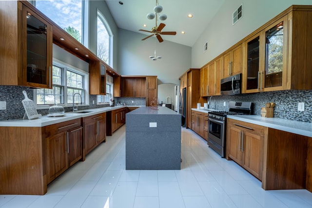 kitchen featuring visible vents, decorative backsplash, a sink, a ceiling fan, and appliances with stainless steel finishes