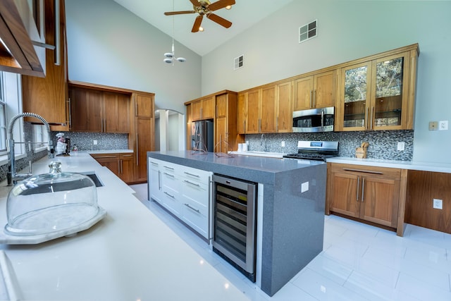 kitchen featuring decorative backsplash, a ceiling fan, high vaulted ceiling, beverage cooler, and stainless steel appliances