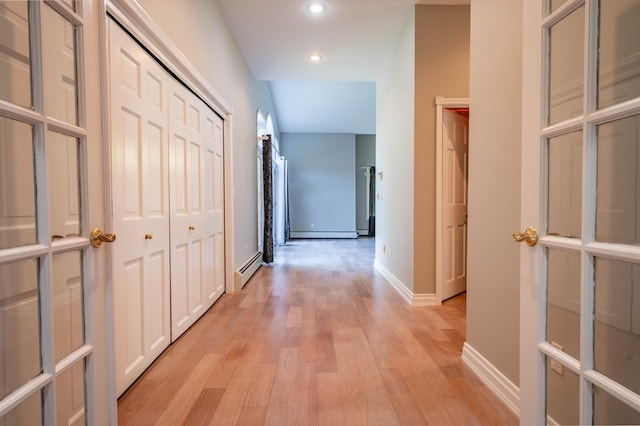 corridor featuring baseboard heating, recessed lighting, baseboards, light wood-type flooring, and a baseboard radiator
