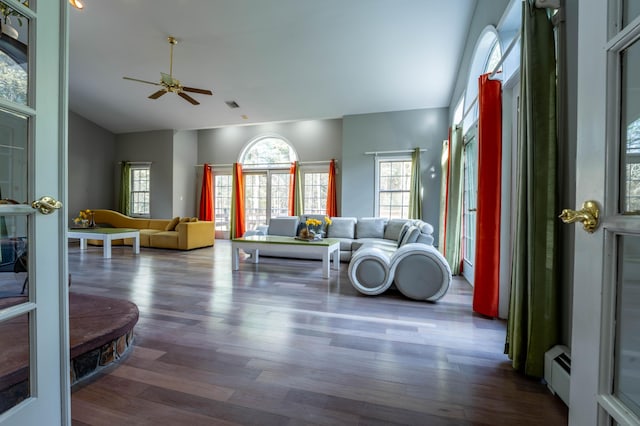 living room with a baseboard heating unit, ceiling fan, wood finished floors, and vaulted ceiling