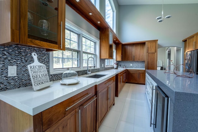 kitchen featuring brown cabinets, stainless steel refrigerator, a sink, and wine cooler