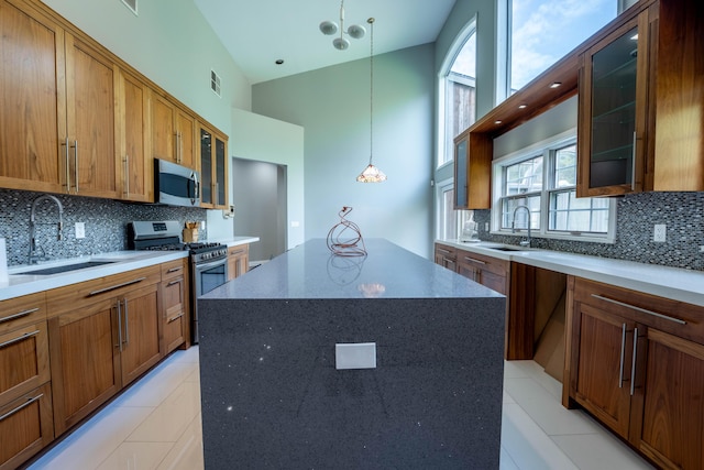 kitchen featuring visible vents, a sink, appliances with stainless steel finishes, and high vaulted ceiling