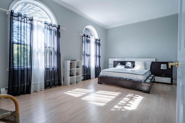 bedroom with crown molding and wood finished floors