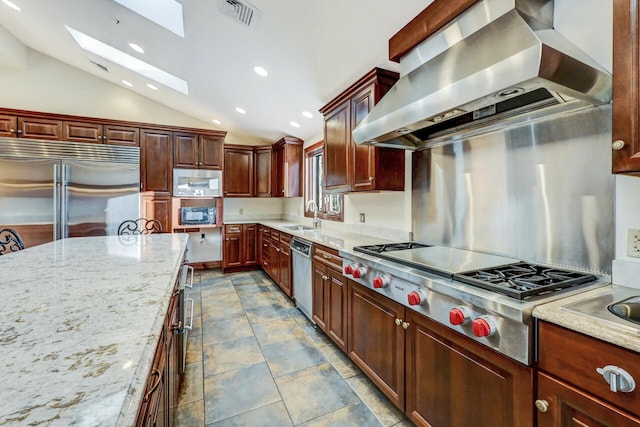 374 Packer Dr, Weatherly, PA 18255 - kitchen featuring built in appliances, light stone countertops, visible vents, wall chimney exhaust hood, and lofted ceiling with skylight