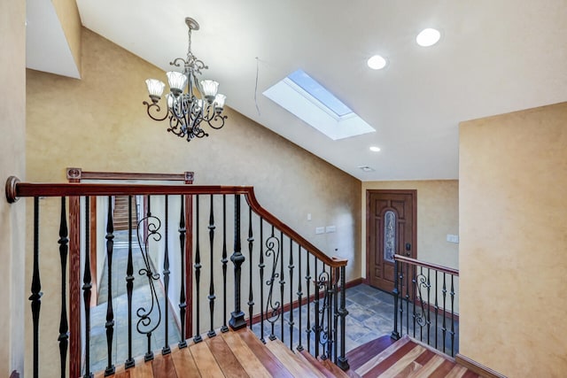 374 Packer Dr, Weatherly, PA 18255 - stairs featuring recessed lighting, vaulted ceiling with skylight, a notable chandelier, and wood finished floors
