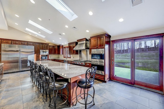 374 Packer Dr, Weatherly, PA 18255 - kitchen featuring a center island, visible vents, wall chimney exhaust hood, lofted ceiling with skylight, and appliances with stainless steel finishes