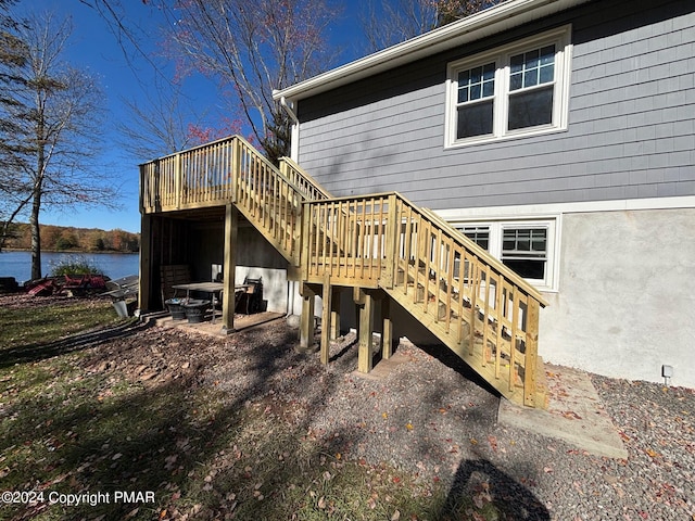 deck featuring stairs and a water view