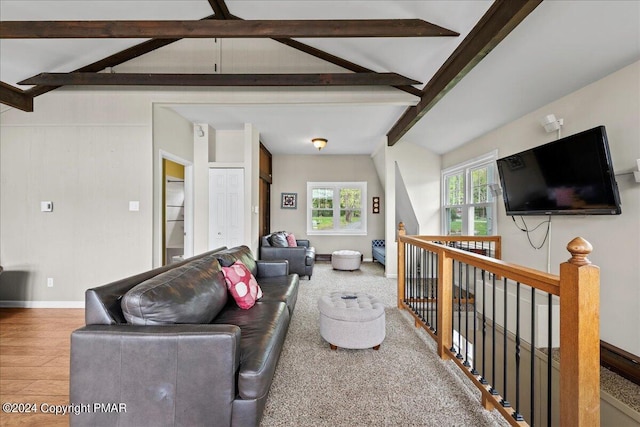 living room with lofted ceiling with beams, wood finished floors, and baseboards