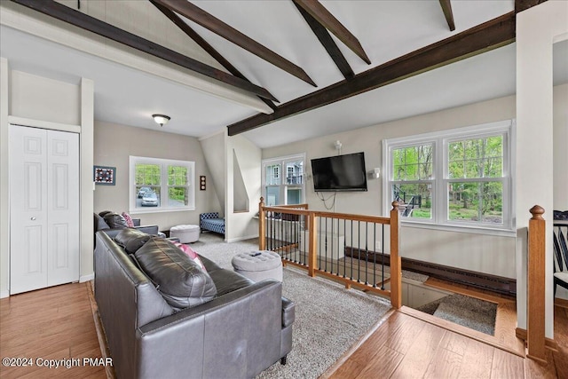 living room with lofted ceiling with beams, wood finished floors, and baseboards