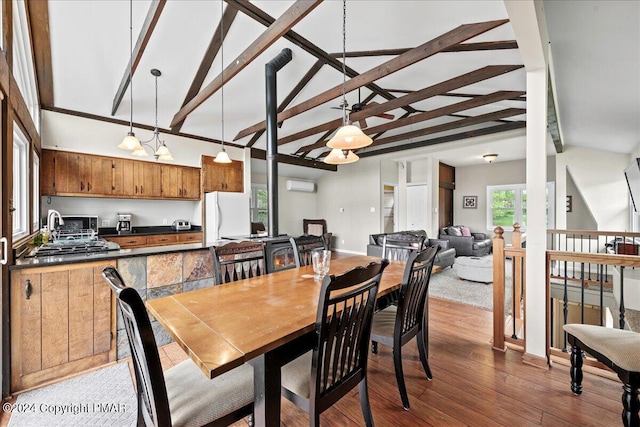 dining room featuring vaulted ceiling with beams, dark wood-style floors, baseboards, and an AC wall unit