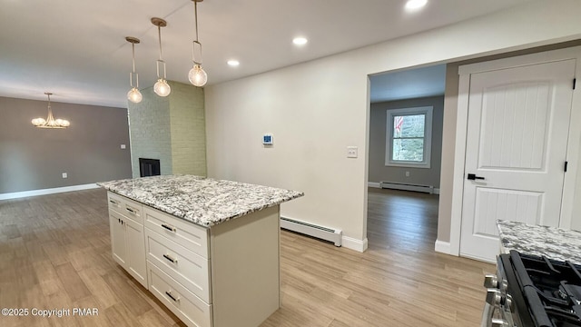 kitchen with stainless steel stove, a kitchen island, white cabinets, and baseboard heating