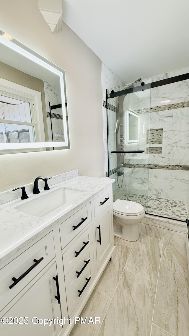 bathroom with vanity, an enclosed shower, and toilet