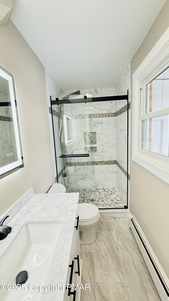 bathroom with baseboard heating, vanity, toilet, and a shower with door