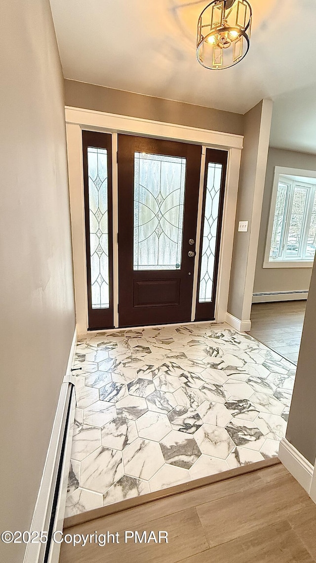 entryway featuring baseboard heating, an inviting chandelier, and hardwood / wood-style flooring