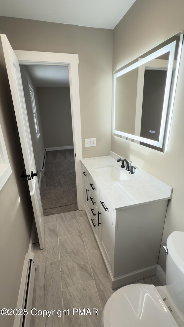 bathroom featuring vanity, baseboard heating, and toilet