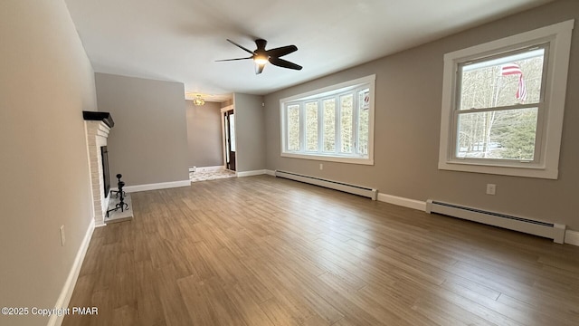 unfurnished living room featuring hardwood / wood-style flooring, a baseboard radiator, a brick fireplace, and ceiling fan