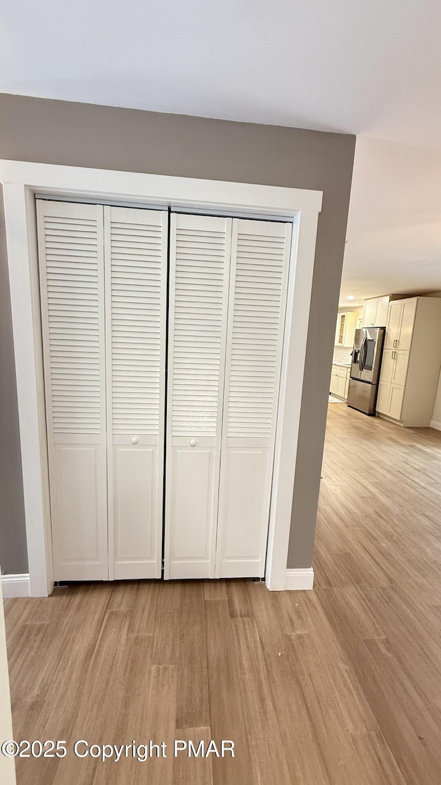 interior details with hardwood / wood-style flooring and stainless steel refrigerator with ice dispenser