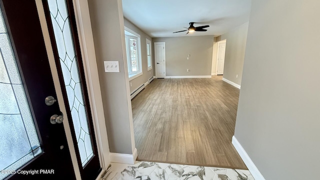 foyer entrance featuring light hardwood / wood-style flooring, ceiling fan, and baseboard heating