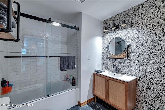 full bathroom with shower / bath combination with glass door, tile patterned flooring, vanity, and baseboards