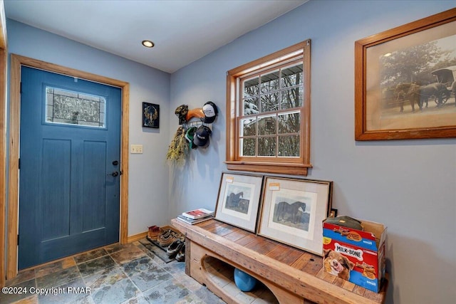 interior space featuring a healthy amount of sunlight, baseboards, stone finish floor, and recessed lighting