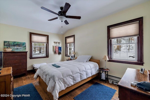 bedroom featuring a baseboard radiator, a ceiling fan, vaulted ceiling, wood finished floors, and baseboards