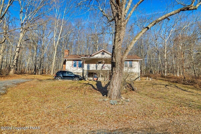 view of front of property featuring a chimney and a front lawn